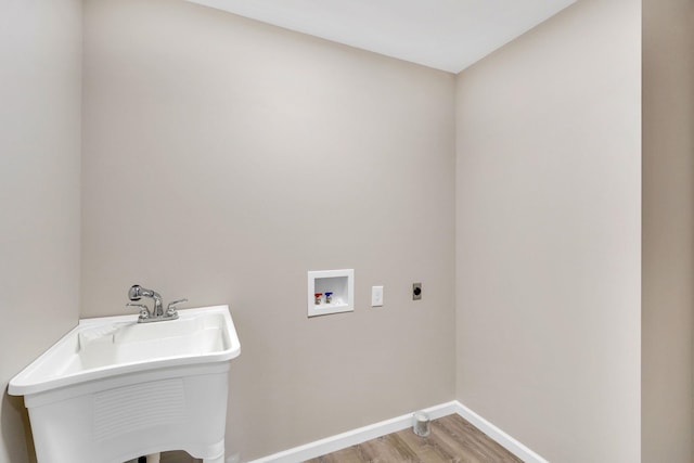 laundry room featuring sink, hookup for an electric dryer, light hardwood / wood-style floors, and hookup for a washing machine