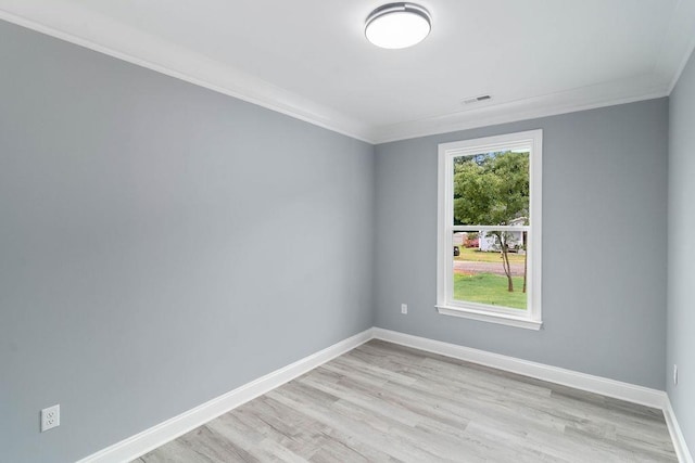 unfurnished room with ornamental molding, light wood-style floors, visible vents, and baseboards