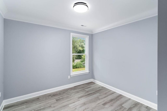 unfurnished room featuring visible vents, baseboards, crown molding, and wood finished floors