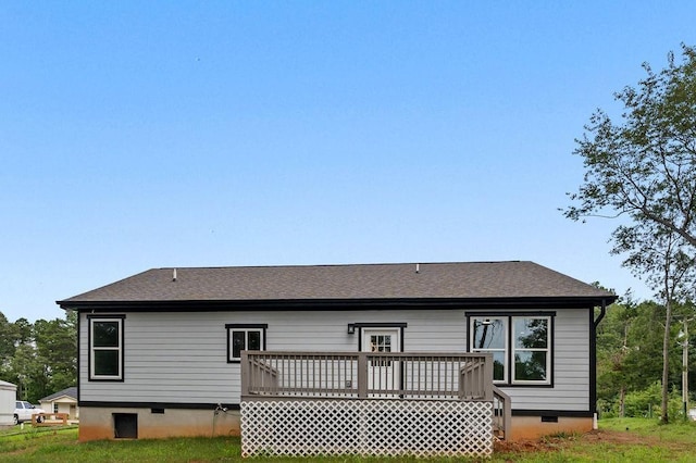 rear view of property with crawl space, roof with shingles, and a deck