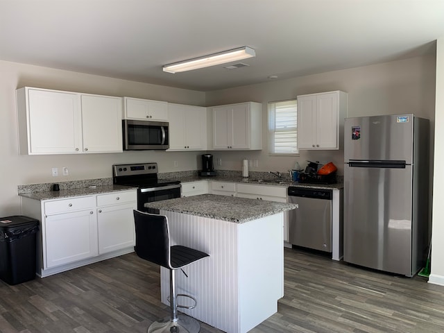 kitchen featuring white cabinetry, a kitchen island, dark hardwood / wood-style floors, stainless steel appliances, and sink