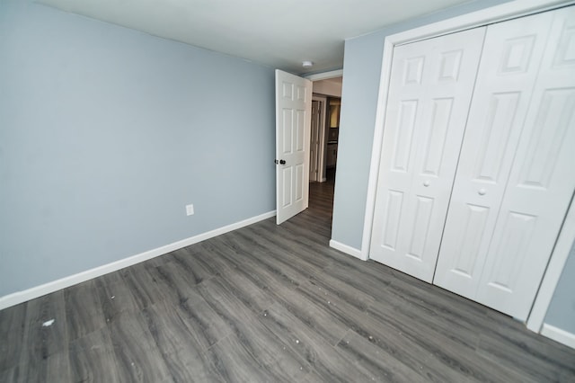 unfurnished bedroom featuring dark hardwood / wood-style floors and a closet