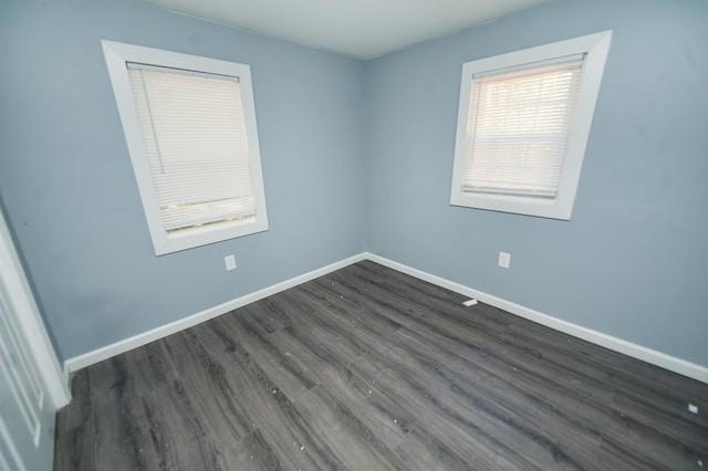 spare room featuring dark hardwood / wood-style floors and plenty of natural light