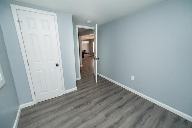 unfurnished bedroom featuring dark hardwood / wood-style flooring and a closet