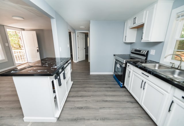 kitchen with wood-type flooring, sink, black electric range oven, and white cabinets