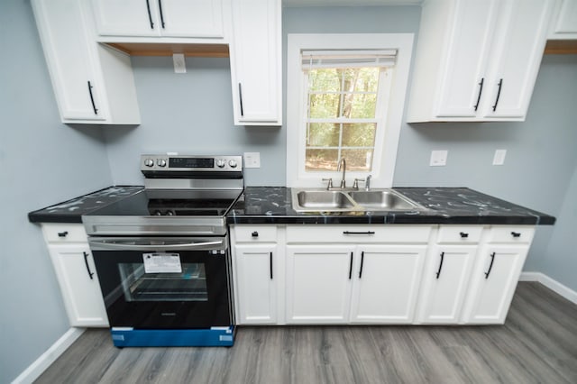 kitchen with light hardwood / wood-style flooring, white cabinets, sink, and electric range oven