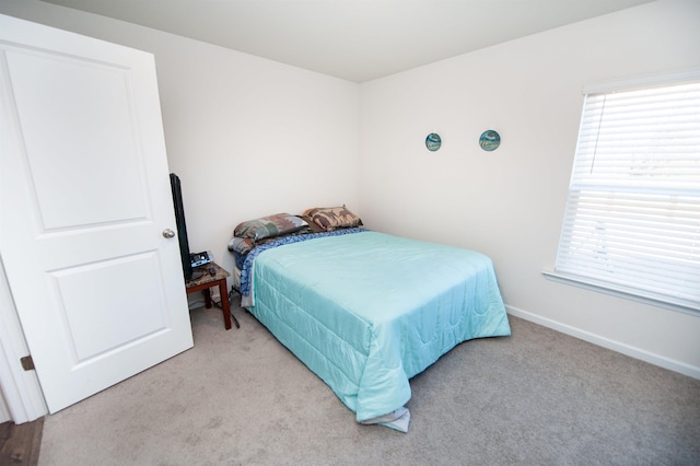 bedroom with multiple windows and light carpet