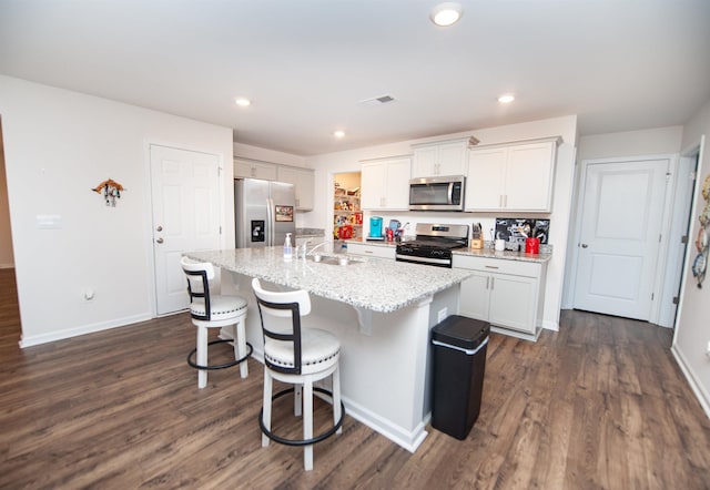 kitchen featuring white cabinetry, appliances with stainless steel finishes, sink, and an island with sink