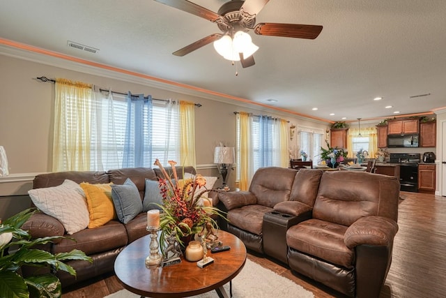 living room with ceiling fan, crown molding, and hardwood / wood-style flooring