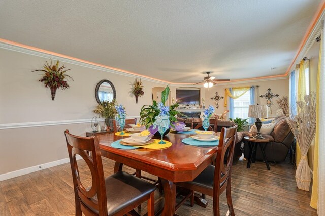 dining room featuring hardwood / wood-style floors, crown molding, a textured ceiling, and ceiling fan