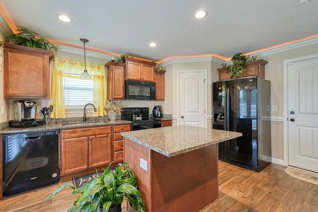 kitchen with wood-type flooring, ornamental molding, sink, and black appliances