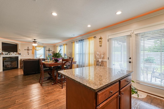 kitchen with ceiling fan, crown molding, hardwood / wood-style flooring, and a wealth of natural light