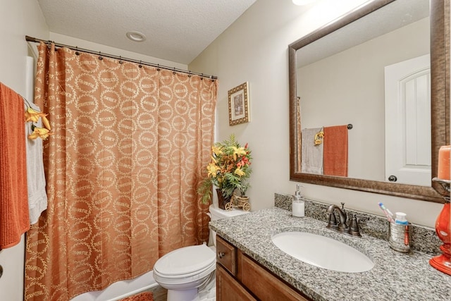 bathroom featuring a textured ceiling, toilet, and vanity