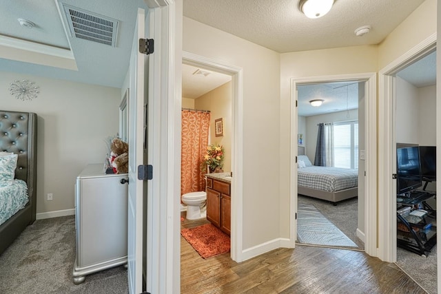 hallway featuring a textured ceiling and carpet