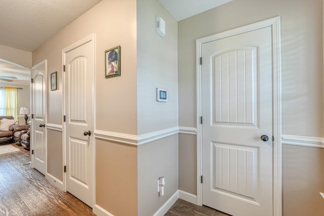 corridor featuring wood-type flooring and a textured ceiling