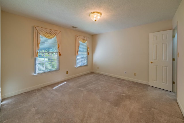 spare room with a textured ceiling and carpet floors