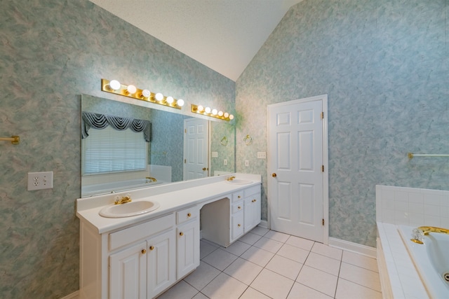 bathroom with a textured ceiling, tiled bath, tile patterned flooring, vaulted ceiling, and dual vanity