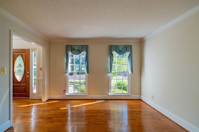 entrance foyer featuring a textured ceiling, light wood-type flooring, and ornamental molding