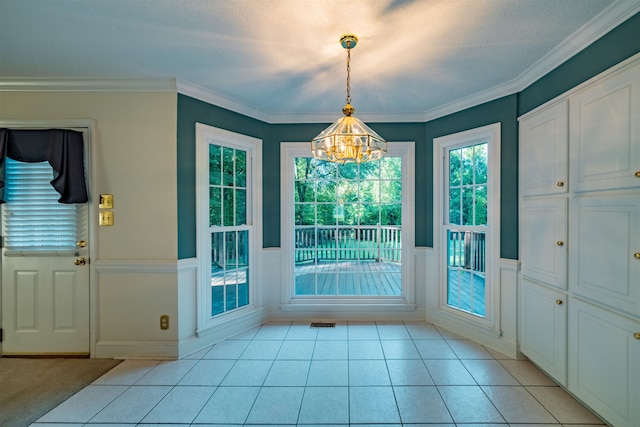 doorway to outside with light tile patterned floors, an inviting chandelier, and crown molding