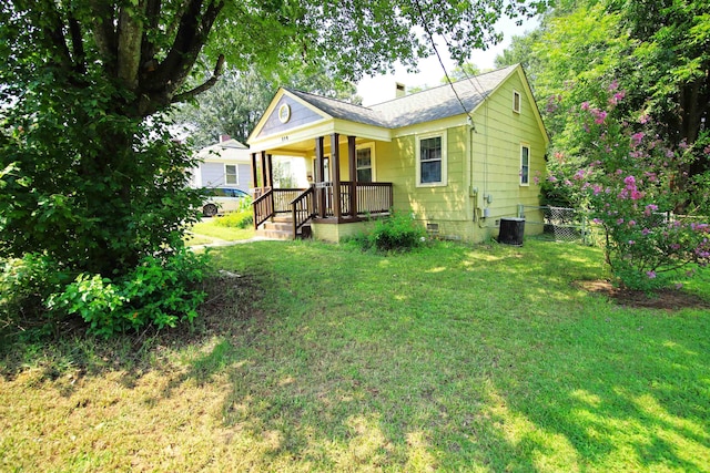 rear view of property featuring central AC, a yard, and covered porch