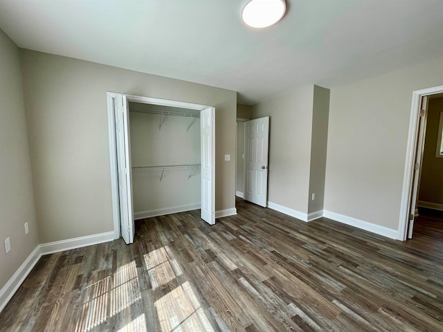 unfurnished bedroom with dark hardwood / wood-style flooring and a closet