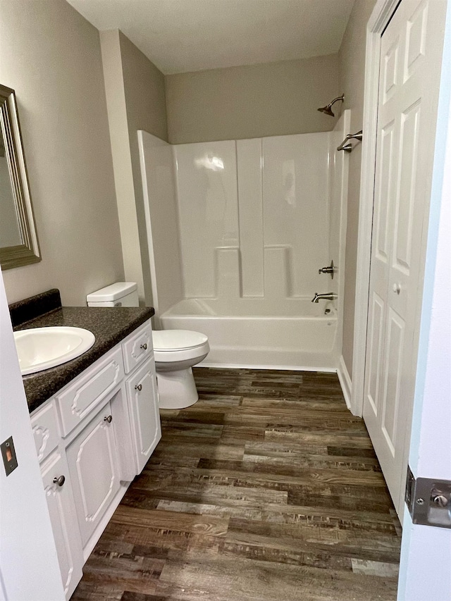 full bathroom with toilet, hardwood / wood-style flooring, vanity, and bathtub / shower combination