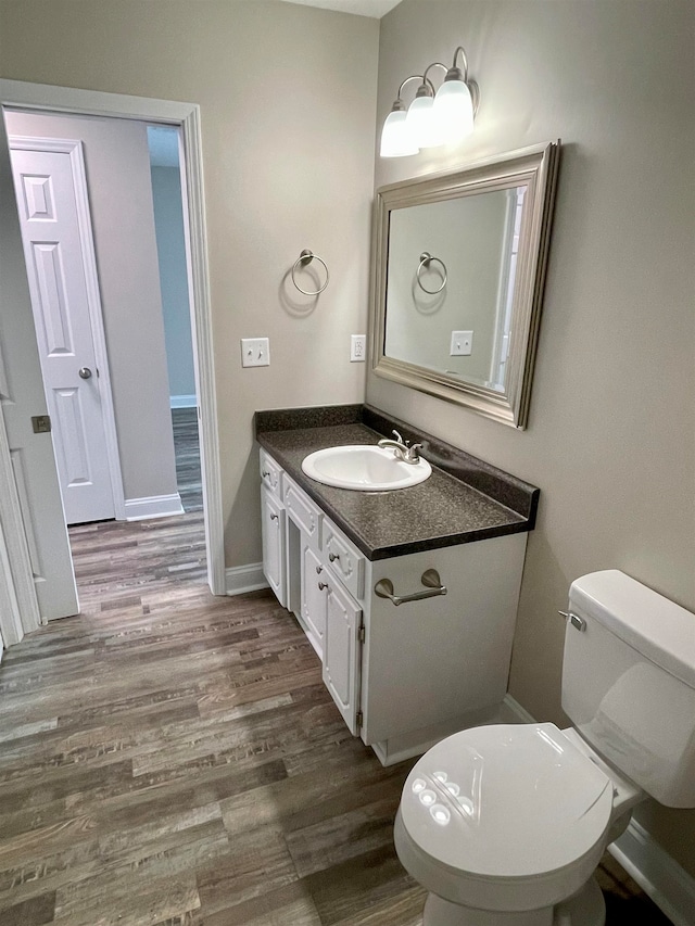 bathroom featuring wood-type flooring, vanity, and toilet