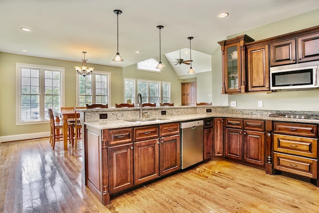 kitchen featuring light wood-type flooring, stainless steel appliances, sink, and a healthy amount of sunlight