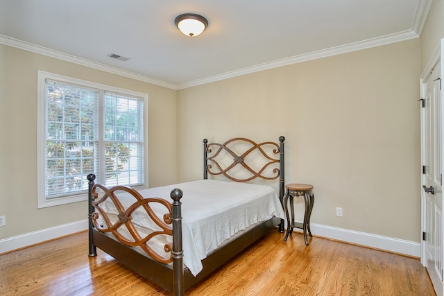 bedroom with light hardwood / wood-style flooring and ornamental molding