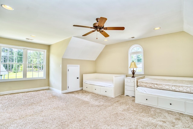 unfurnished bedroom featuring lofted ceiling, light colored carpet, ceiling fan, and multiple windows