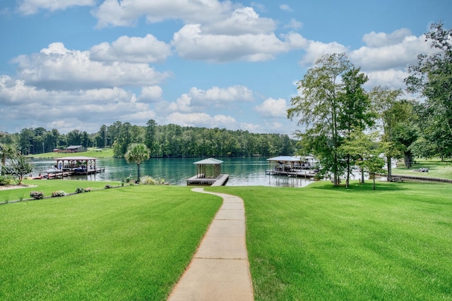 view of property's community featuring a lawn, a boat dock, and a water view