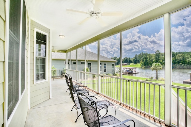 sunroom / solarium with ceiling fan and a water view