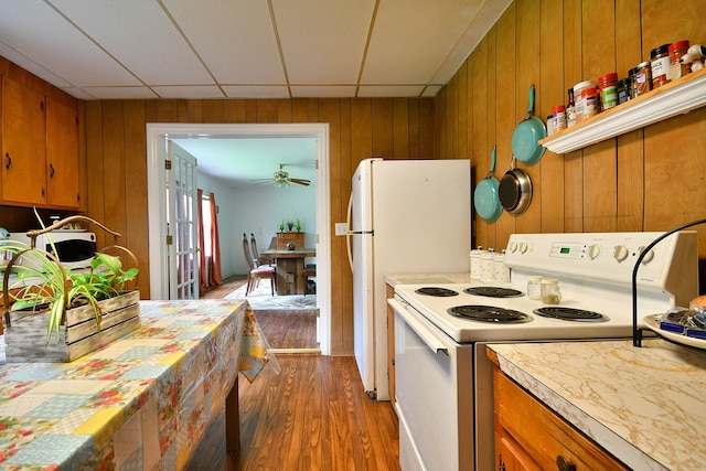 kitchen with wood walls, a paneled ceiling, hardwood / wood-style flooring, and white electric range