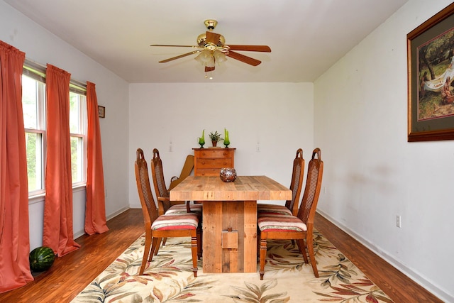 dining area with a ceiling fan, baseboards, and wood finished floors