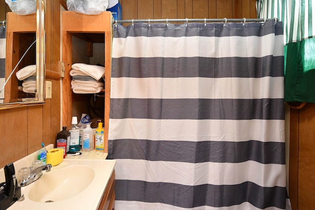 bathroom featuring wooden walls and vanity