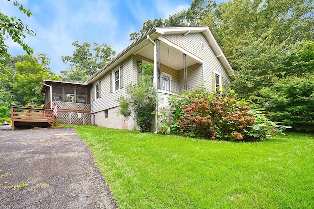 view of home's exterior featuring a lawn and a sunroom