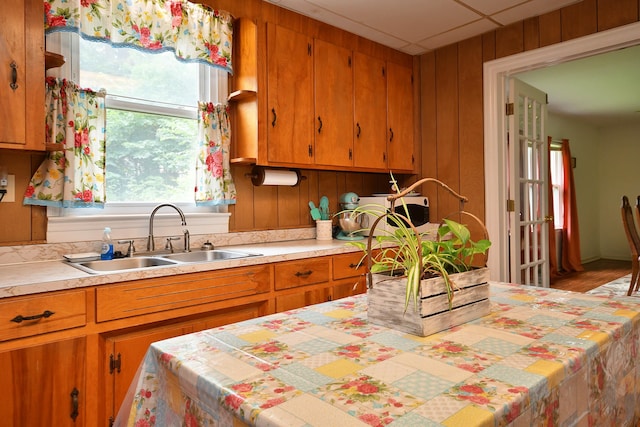 kitchen featuring wood walls, sink, and wood-type flooring