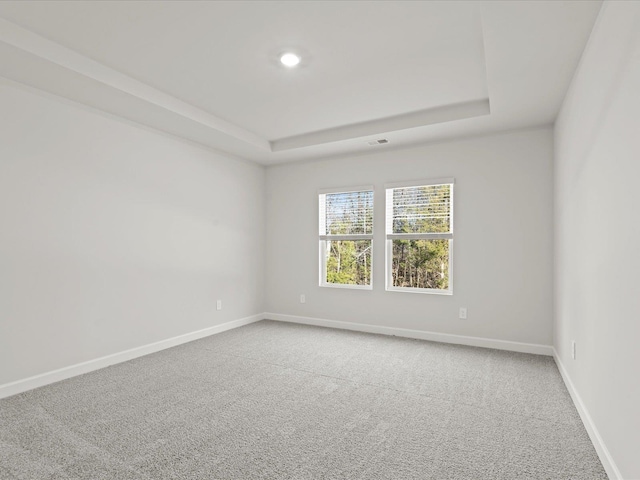 spare room featuring recessed lighting, a raised ceiling, visible vents, carpet flooring, and baseboards