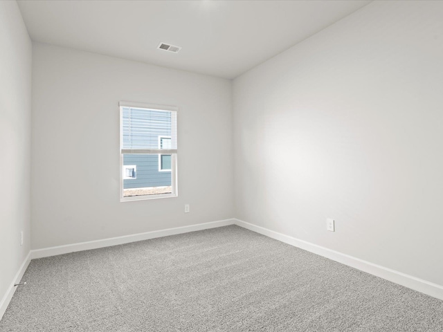 unfurnished room featuring baseboards, visible vents, and carpet flooring