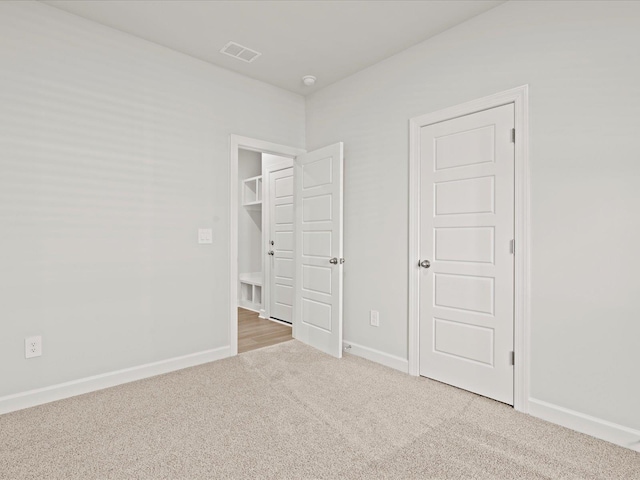 unfurnished bedroom featuring carpet, visible vents, and baseboards