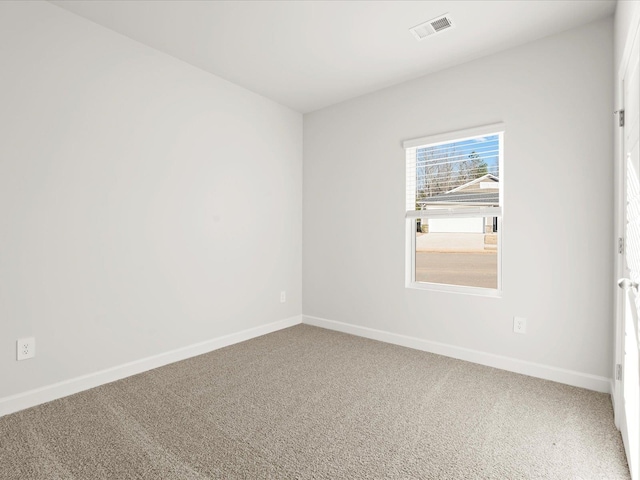 carpeted empty room with visible vents and baseboards