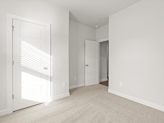 unfurnished bedroom with carpet floors, visible vents, and baseboards