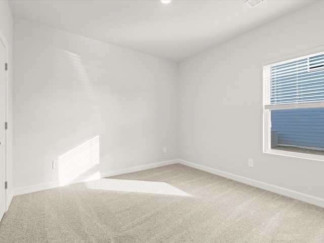 unfurnished room featuring carpet and baseboards