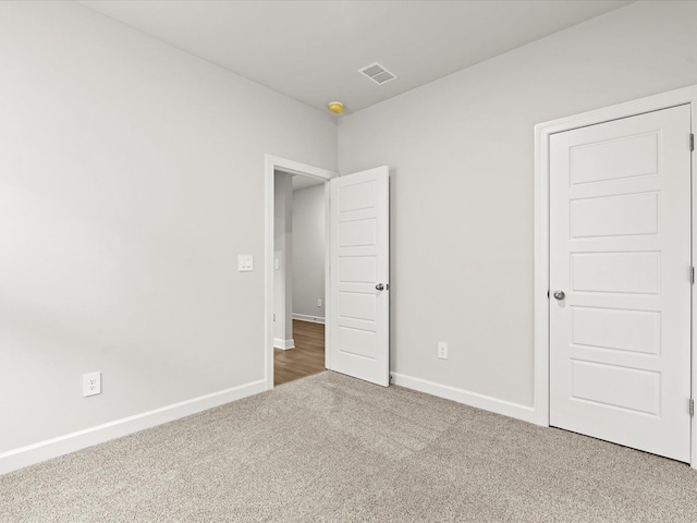 unfurnished bedroom with carpet, visible vents, and baseboards