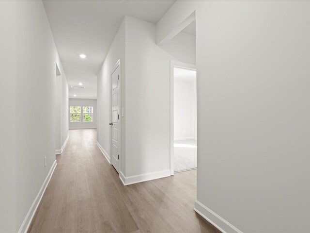 hallway with baseboards, wood finished floors, and recessed lighting