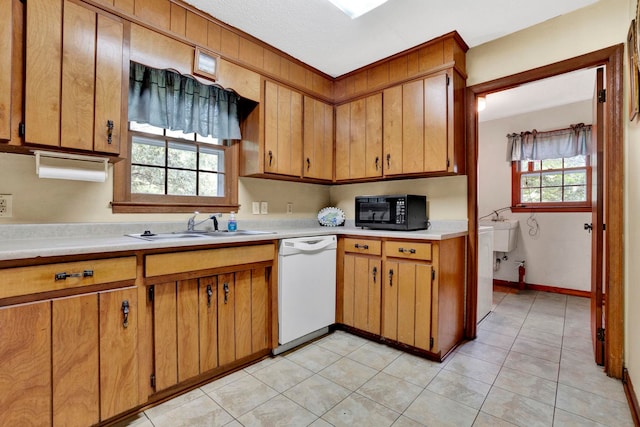 kitchen featuring sink, light tile patterned flooring, and white dishwasher