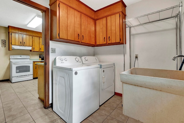 laundry area featuring washer and dryer, a textured ceiling, and light tile patterned flooring