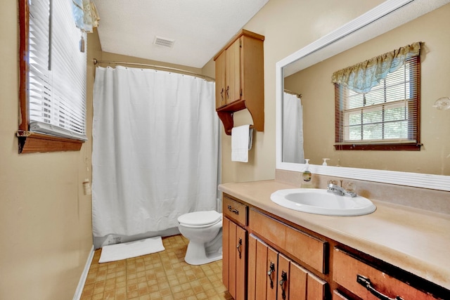 bathroom with toilet, vanity, and tile patterned floors