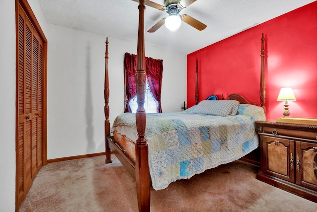 bedroom with ceiling fan, a closet, a textured ceiling, and light colored carpet