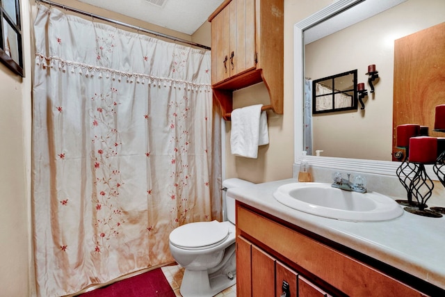 bathroom featuring tile patterned flooring, toilet, a textured ceiling, and vanity